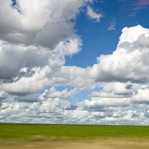 View of Cumulus Clouds Spread Over Green Fields
