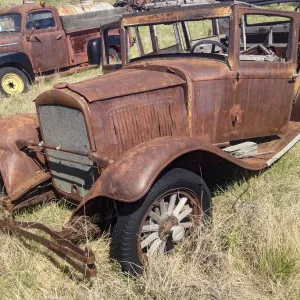 Vintage vehicles left to rot in a prairie scrapyard