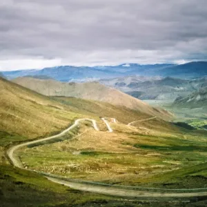 Winding mountain road in storm in Himalayas Tibet Winding mountain road in storm in Himalayas Tibet