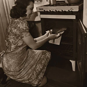 Woman baking bread in kitchen (B&W sepia tone)
