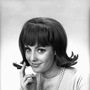 Woman with cigarette posing in studio, (B&W), portrait