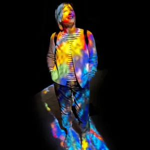 Woman in the colourful light of a stained glass window Woman in the colourful light of a stained glass window