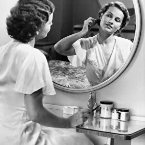 Woman doing hair in front of mirror, (B&W)