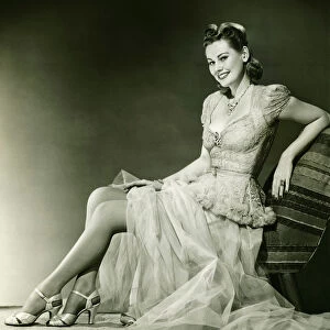 Woman in evening gown posing in studio, (B&W), portrait
