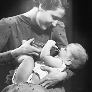 Woman feeding baby (6-9 months) in studio (B&W)