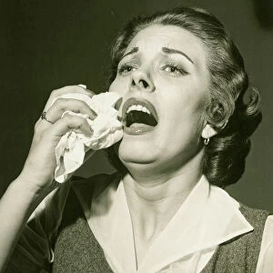 Woman holding handkerchief about to sneeze, (B&W), close-up