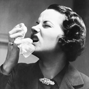 Woman holding tissue, sneezing (B&W)