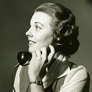 Woman on landline phone posing in studio, (B&W), portrait
