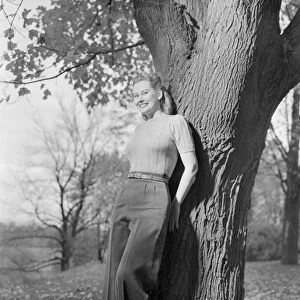 Woman leaning against tree, portrait