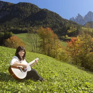 Woman playing guitar in the mountains