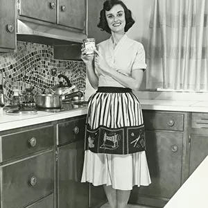 Woman posing in kitchen, (B&W), portrait