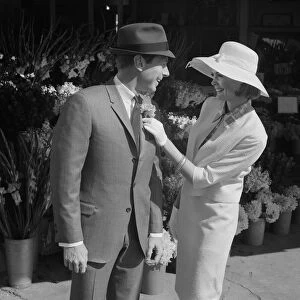 Woman putting flower on mans suit