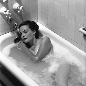 Woman relaxing in bath, (B&W), elevated view