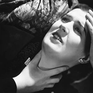 Woman suffering headache, laying in pillow, (B&W), close-up