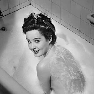 Woman taking bubble bath, (B&W), elevated view
