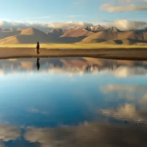 Woman walk along Namtso lake in Tibet Woman walk along Namtso lake in Tibet