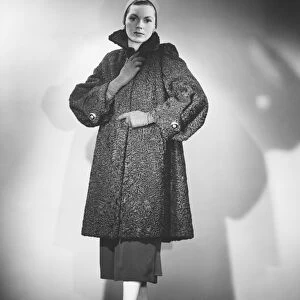 Woman wearing fur coat posing in studio (B&W)