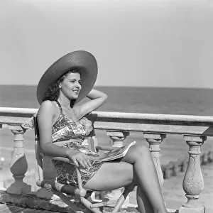 Woman wearing a hat, posing at the beach