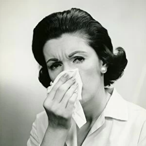 Woman wiping nose with handkerchief, (B&W), (Portrait)