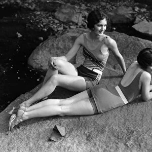 Two women relaxing on rock, by creek. (Photo by H. Armstrong Roberts / Retrofile / Getty Images)
