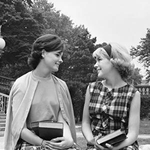 Two women sitting on school campus, talking