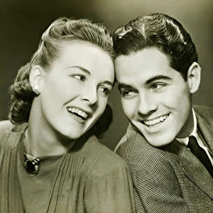 Young couple with head to head, smiling, (B&W)