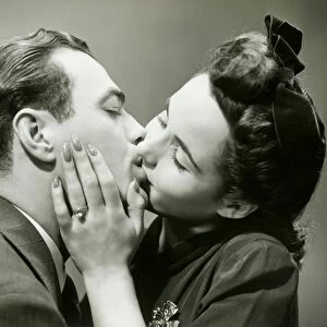 Young couple kissing, close-up, studio shot