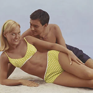 Young couple lying on sand, smiling