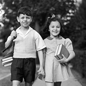 Young girl & boy walking to school w / books