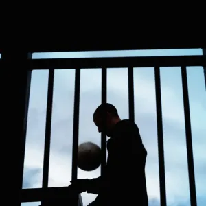 Young man with football by stairs and railing, silhouette Young man with football by stairs and railing, silhouette