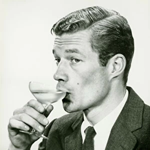 young man in suit, drinking wine (B&W), portrait