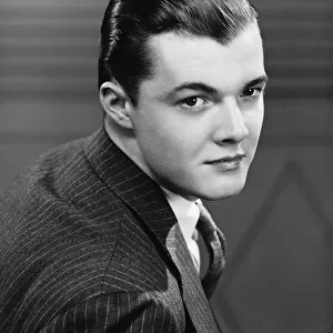 Young man wearing pinstripe jacket, (B&W), portrait