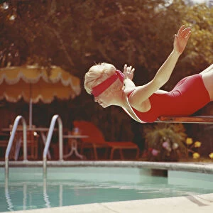 Young woman with blindfold balancing on diving board