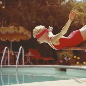 Young woman with blindfold balancing on diving board