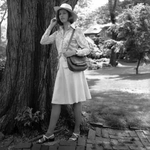 Young woman in hat standing by tree, (B&W) Young woman in hat standing by tree, (B&W)