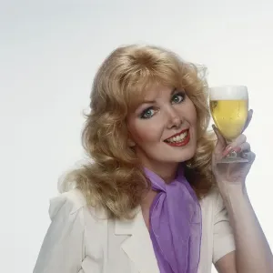 Young woman holding beer glass, smiling, portrait