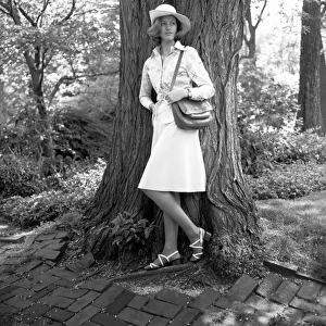 Young woman leaning by tree, (B&W)