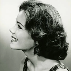 Young woman smiling, posing in studio, (B&W), close-up