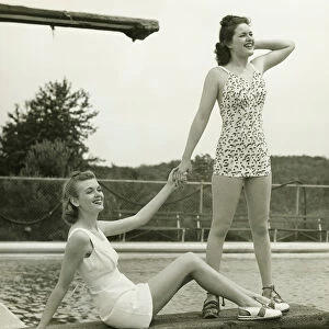 Two young women holding hands on springboard, (B&W)