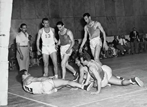 Prints of Argentinian basketball player Juan Uder (1927-2020; No 12) having been pulled down by Uruguayan basketball player Tabare Larre Borges (1922-date of death unknown; second right) Courtside Vibes: Stunning Basketball Prints: 1952 Summer Olympics - Basketball