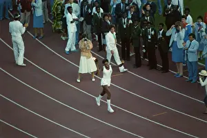 Prints of Gina Hemphill carries the Olympic torch during the opening ceremony of the 1984 Summer Olympics, as seen from the upper tier of the Los Angeles Memorial Coliseum in Los Angeles, California Jesse Owens Prints: 1984 Summer Olympics - Opening Ceremony