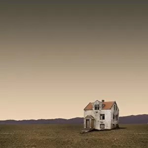 Abandoned house in field at dusk