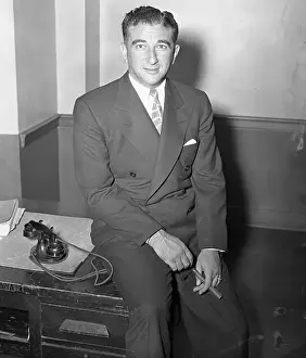 Abner Zwillman Sitting on Edge of Desk with Cigar in Hand