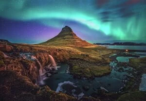 Northern Lights: A Dance of Colours Collection: active aurora borealis storm display over iconic shape of mountain kirkjufell, Iceland