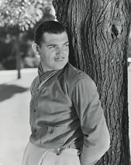 Actor Clark Gable Posing Against a Tree