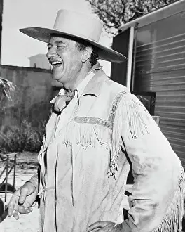 Actor John Wayne Wearing Cowboy Outfit and Laughing
