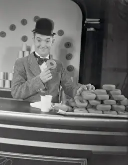 Prints of (Original Caption). Los Angeles, California: Shucks, Stan Sold More Than He Could Eat Timeless Comedy Icons: Classic Moments from the Legendary Duo: Actor Stan Laurel at Donut Display