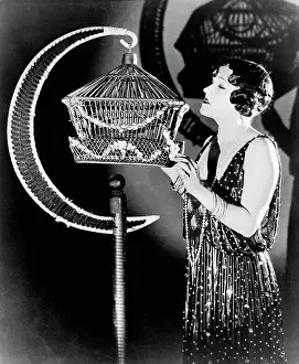 Actress Gloria Swanson Examining a Bird Cage