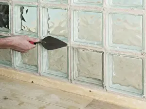 Trowel Prints: Adding grout to joints around a glass block with a trowel