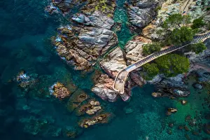 Aerial picture of the Costa Brava shoreline with crystal blue waters and couple of girls doing kayak on summertime